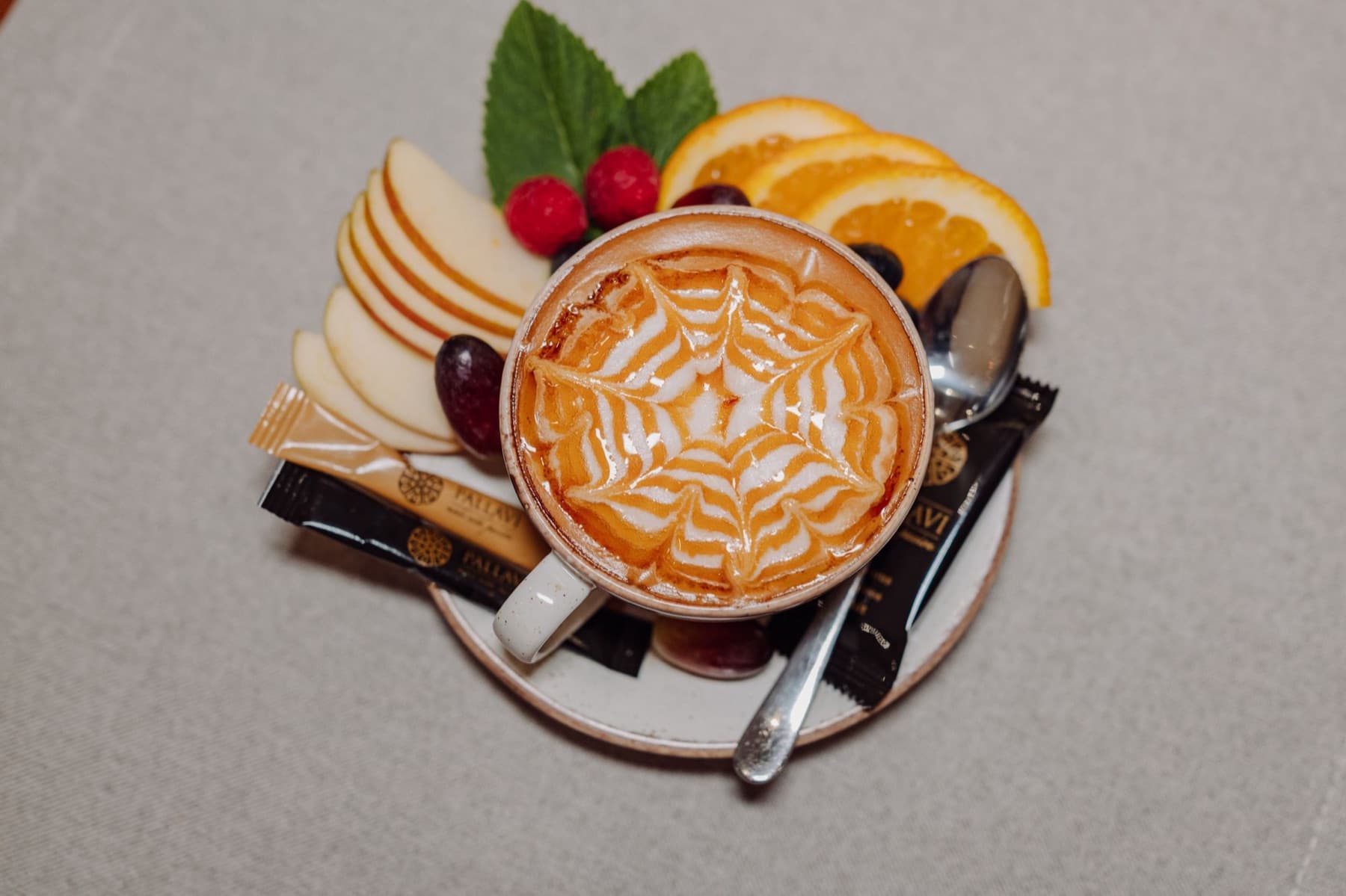 Cappuccino z latte art podane z owocami