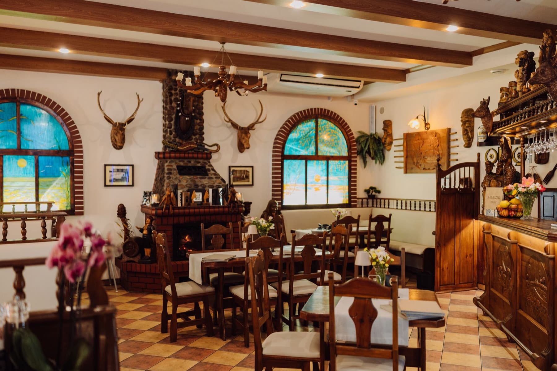Wnętrze restauracji Kabaczek z drewnianymi meblami i kominkiem